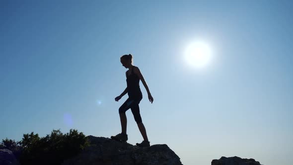 Young Woman Walks Uphill Towards the Summit in Slow Motion. Silhouette of a  Lady Hiking in Beautiful by jm_video